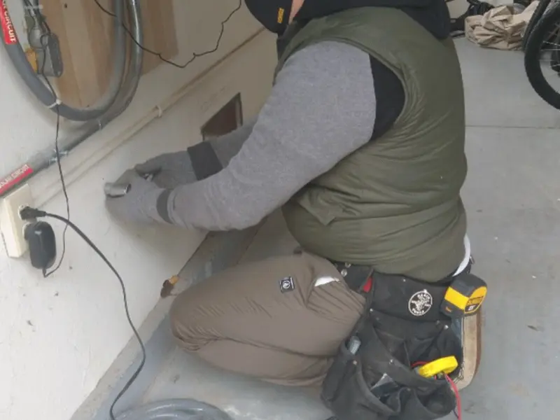 Electrician performing outlet wiring in a Surf City garage